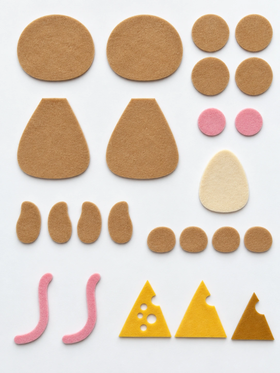 Twenty-four cut felt pieces for the mouse ornament arranged in groups, including paired head and body pieces, ears, paws, tail, and cheese