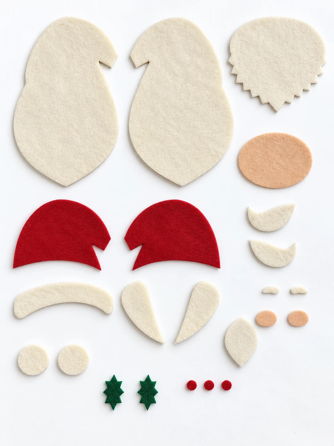 All 23 cut felt pieces for the Santa ornament, including two main bases, two red hats, paired nose and pom-pom pieces, and three red berries