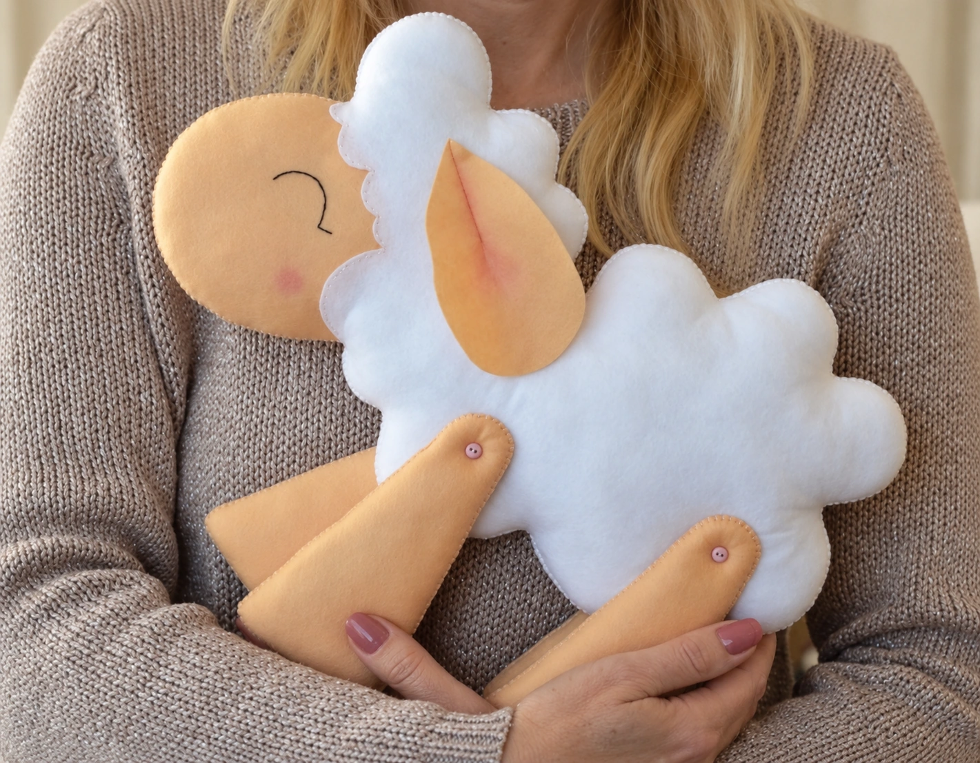 The completed felt sheep held to show its overall shape