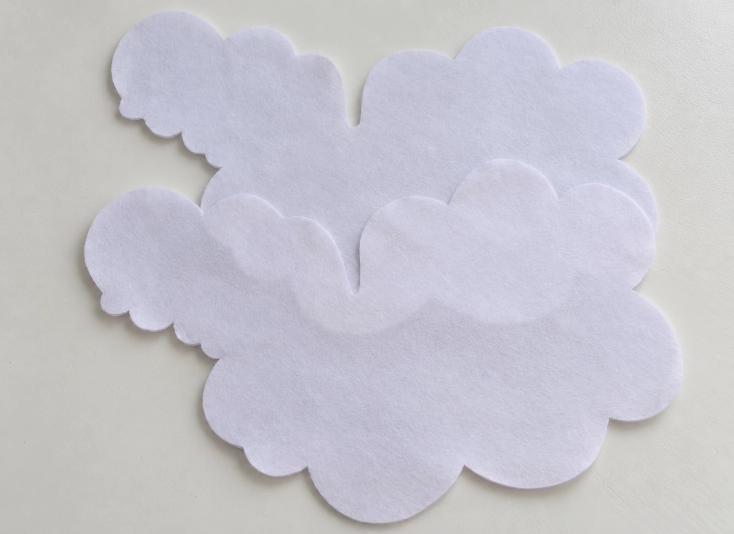 Two matching white felt sheep body pieces
