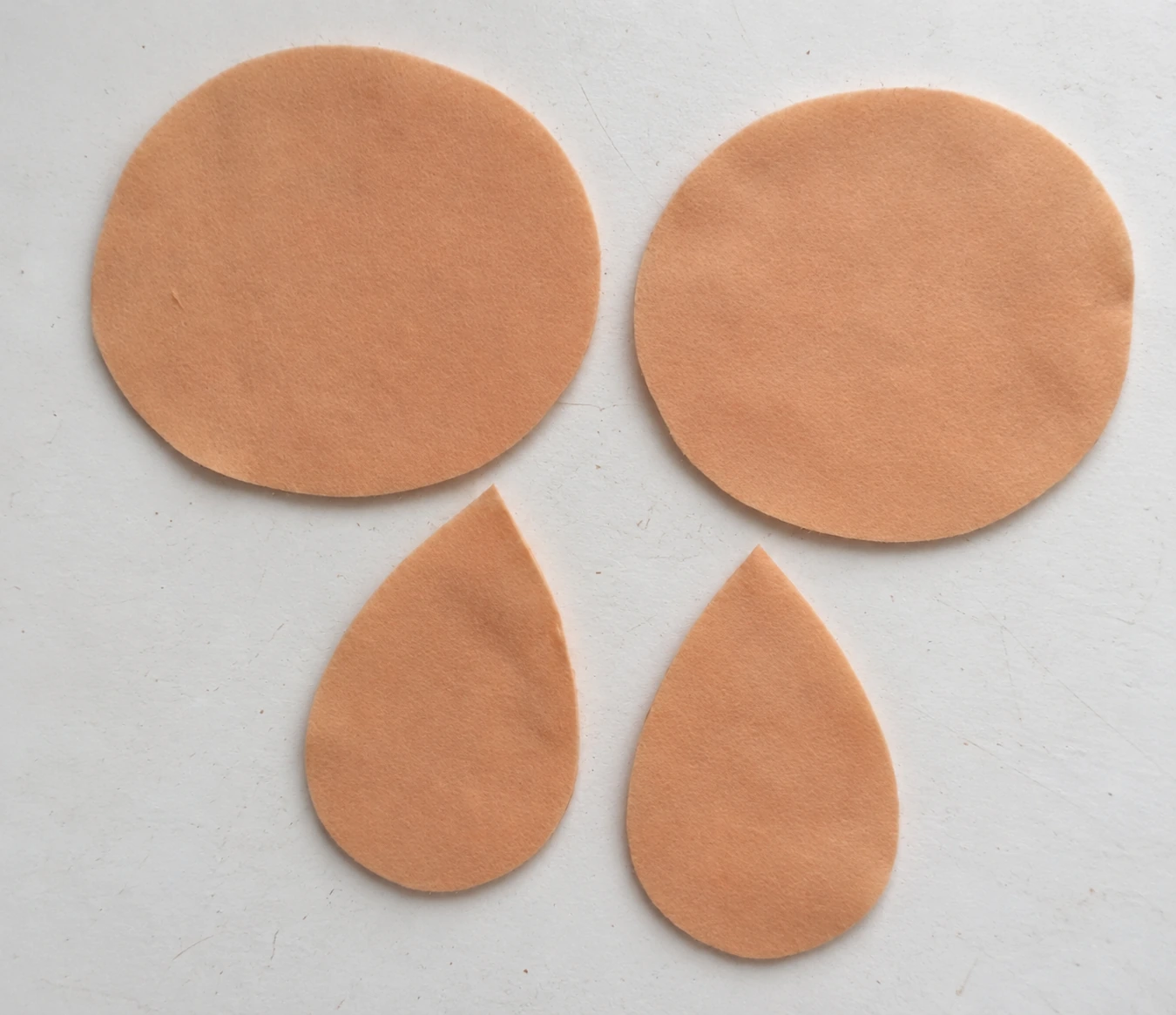 Two beige face circles and two pointed felt ear pieces