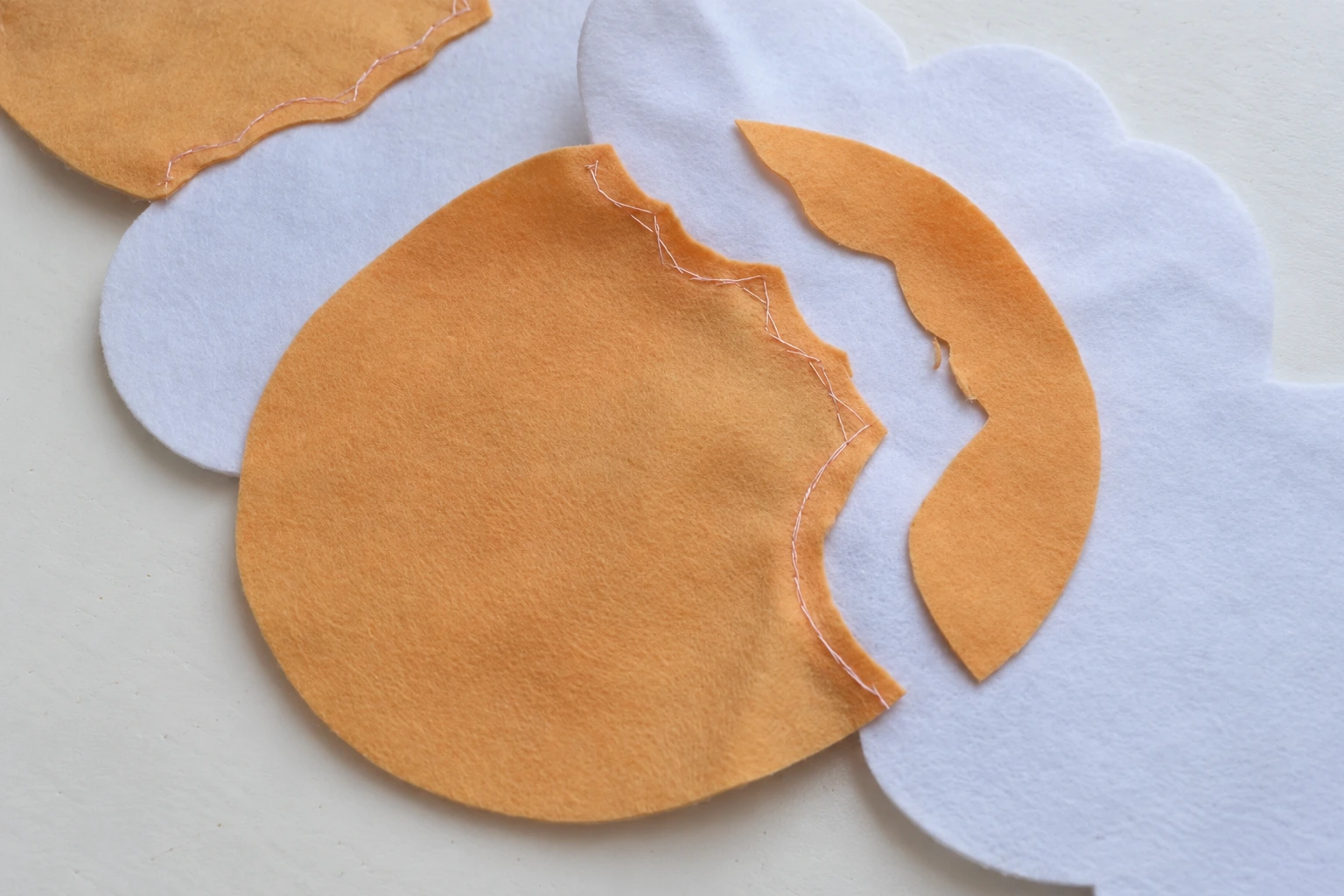 Excess beige overlap trimmed from behind the white felt head