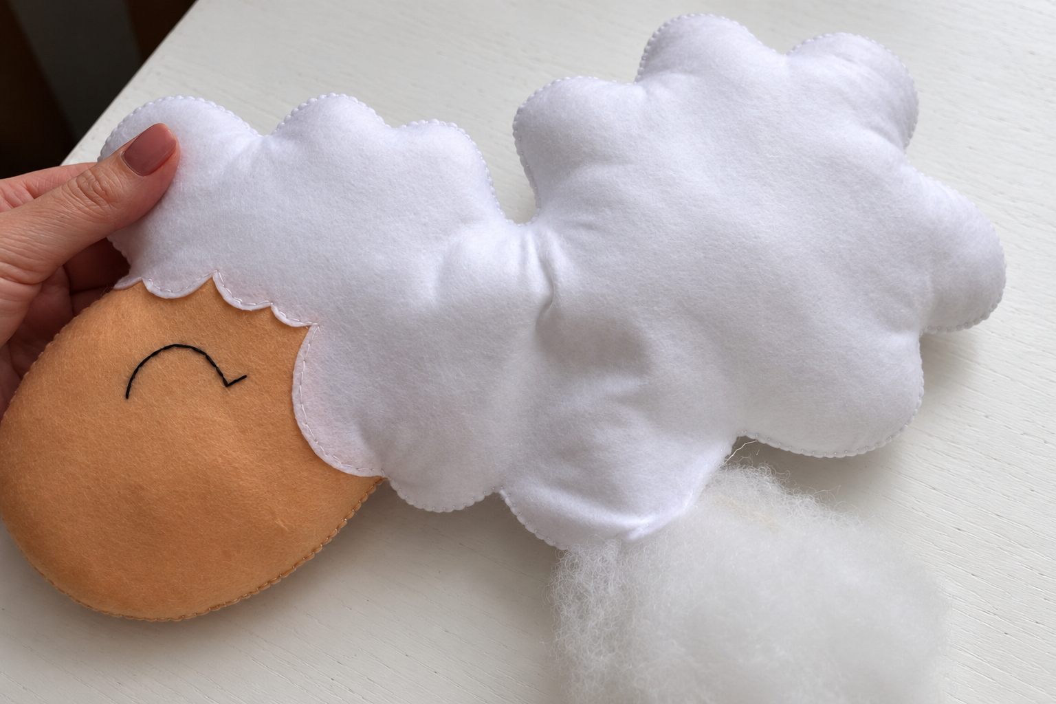 The sheep body held flat while small amounts of stuffing are added