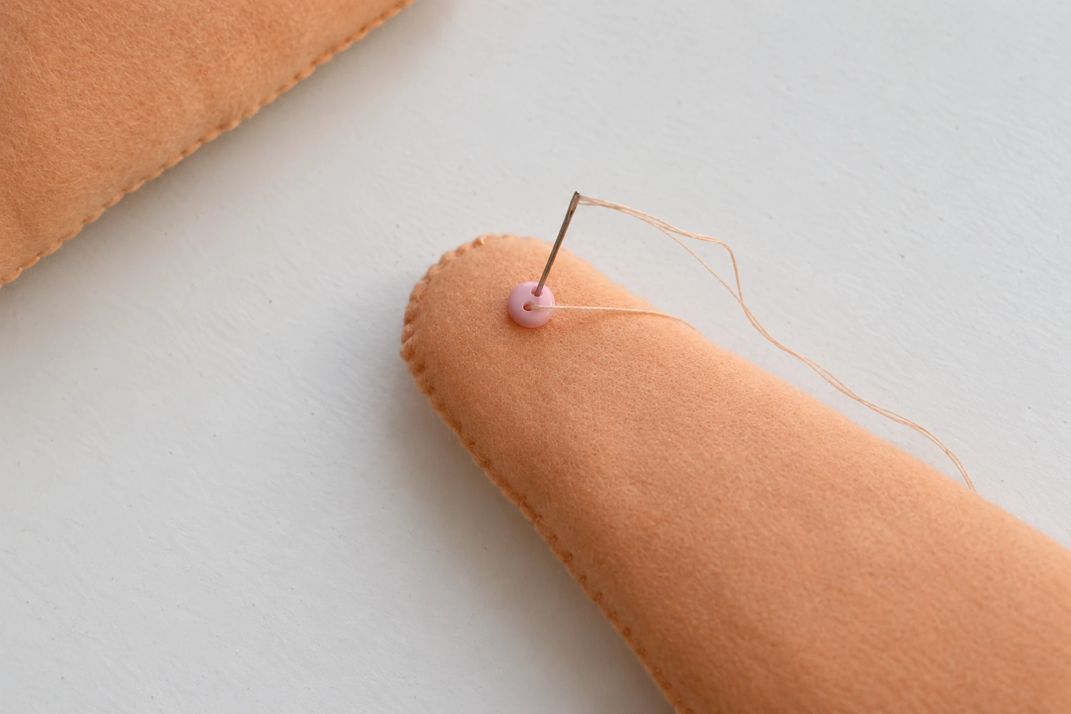 A small button added to the outside of the first felt leg