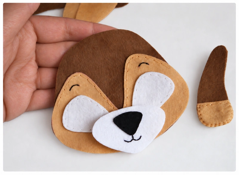Black nose sewn in place and eyebrows and mouth embroidered