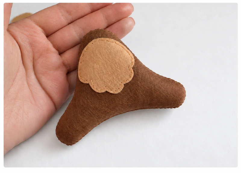 Stuffed brown felt body with its opening sewn closed