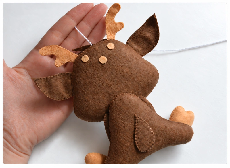 Small beige felt spots decorating the back of the fawn’s head