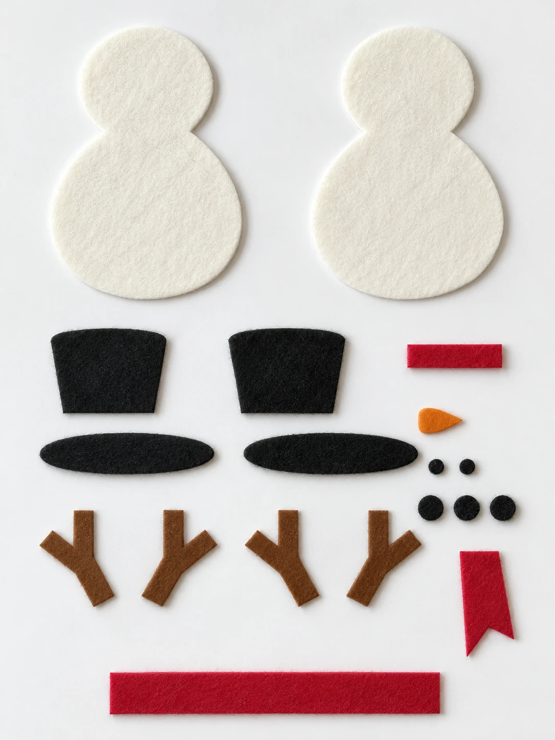 Nineteen cut felt pieces arranged on a white surface for the snowman ornament.